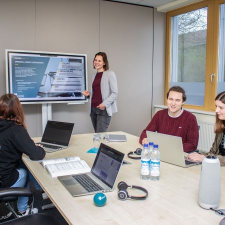 Bild unserer Kolleg:innen fotografiert in einer Bürozsene